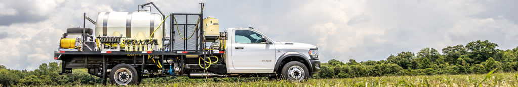 Right-Of-Way Sprayers mounted on a white RAM truck in a field